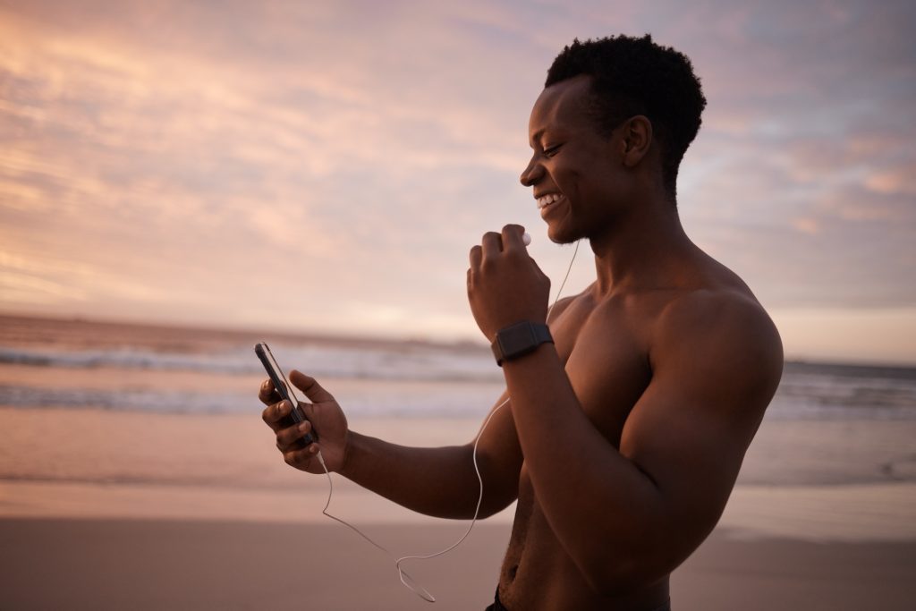 Smiling young African American muscular fit man with athletic body looking happy and relaxed while